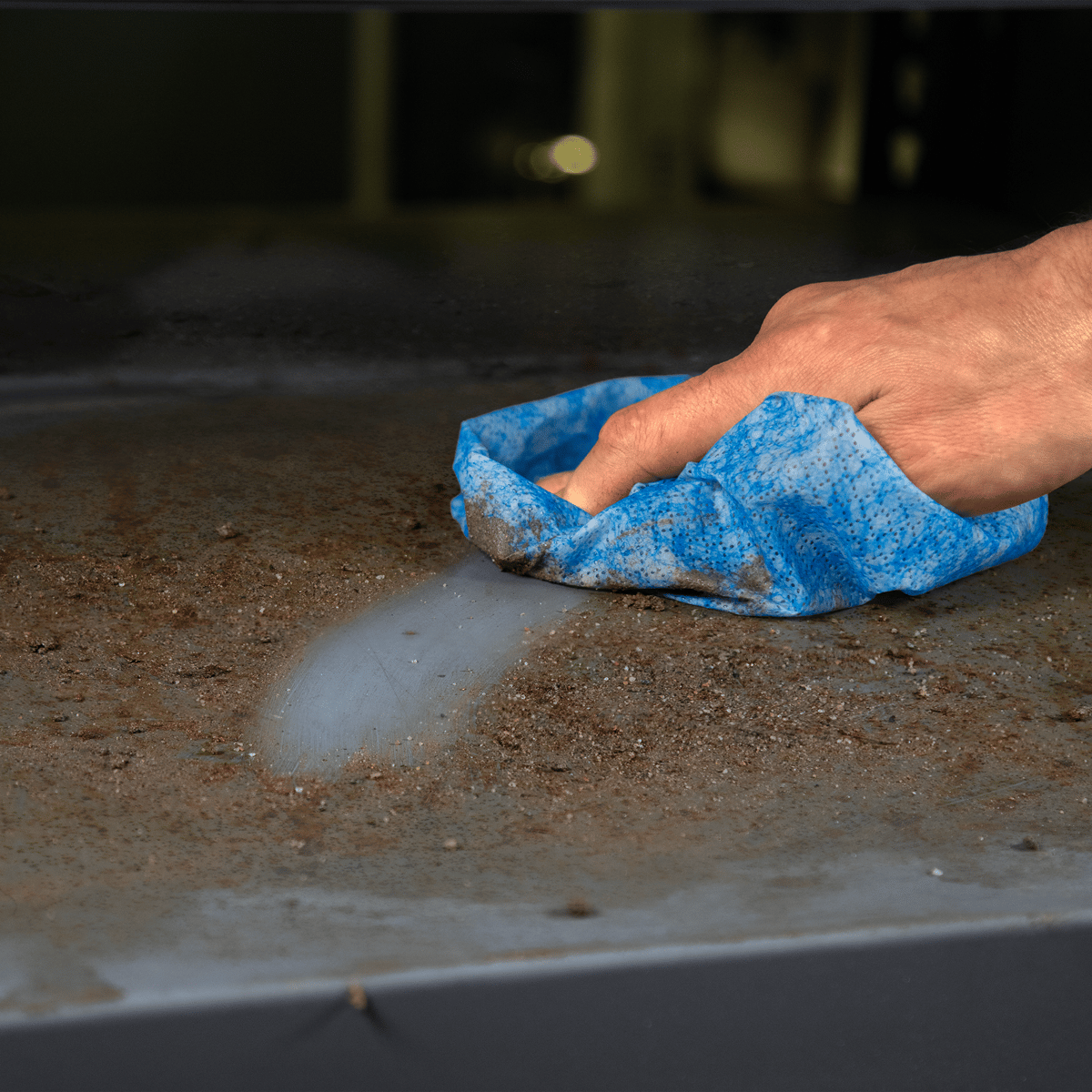 Worker wiping down a work surface with a SCRUBS towel
