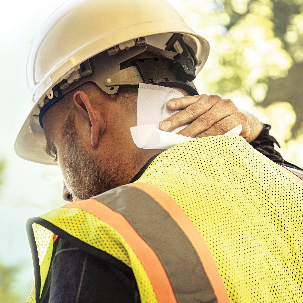 Worker applying a SCRUBS Insect Shield repellent wipe outdoors