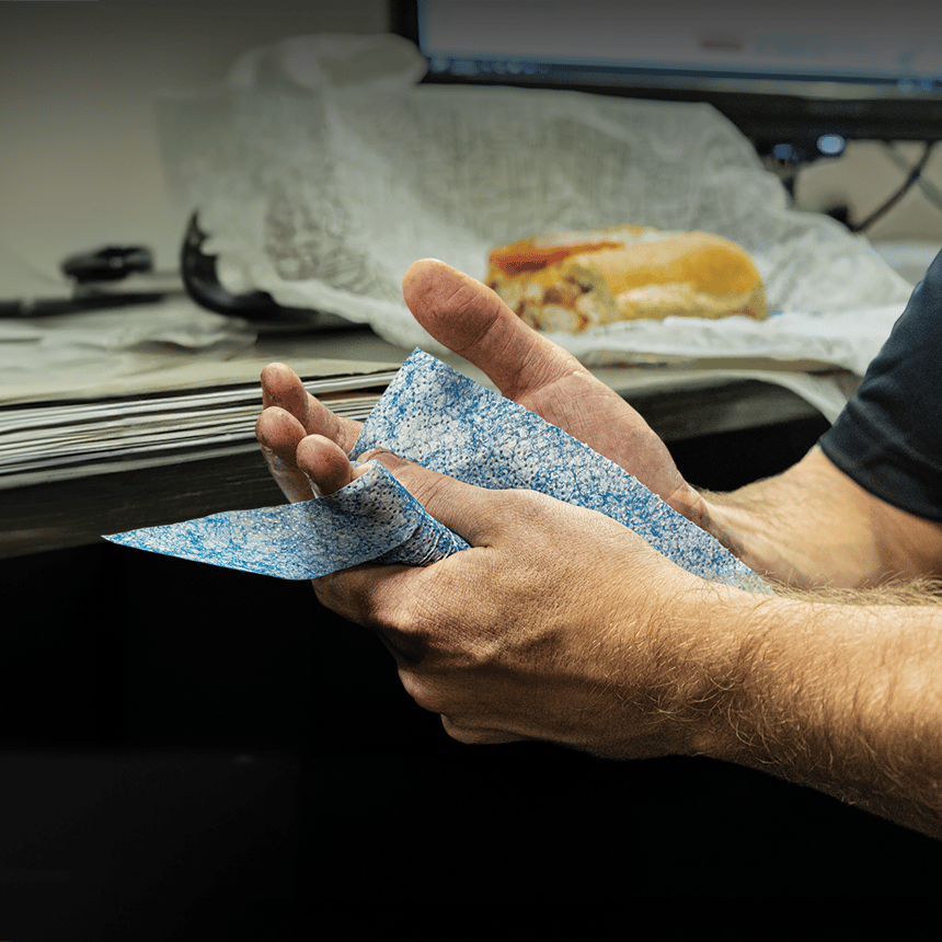 Worker sanitizing hands with a SCRUBS Hand Sanitizer Wipe