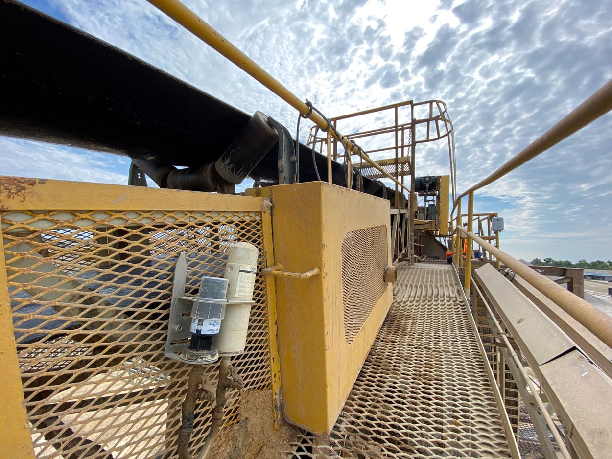 Intelli-Lube installation beside an aggregate conveyor